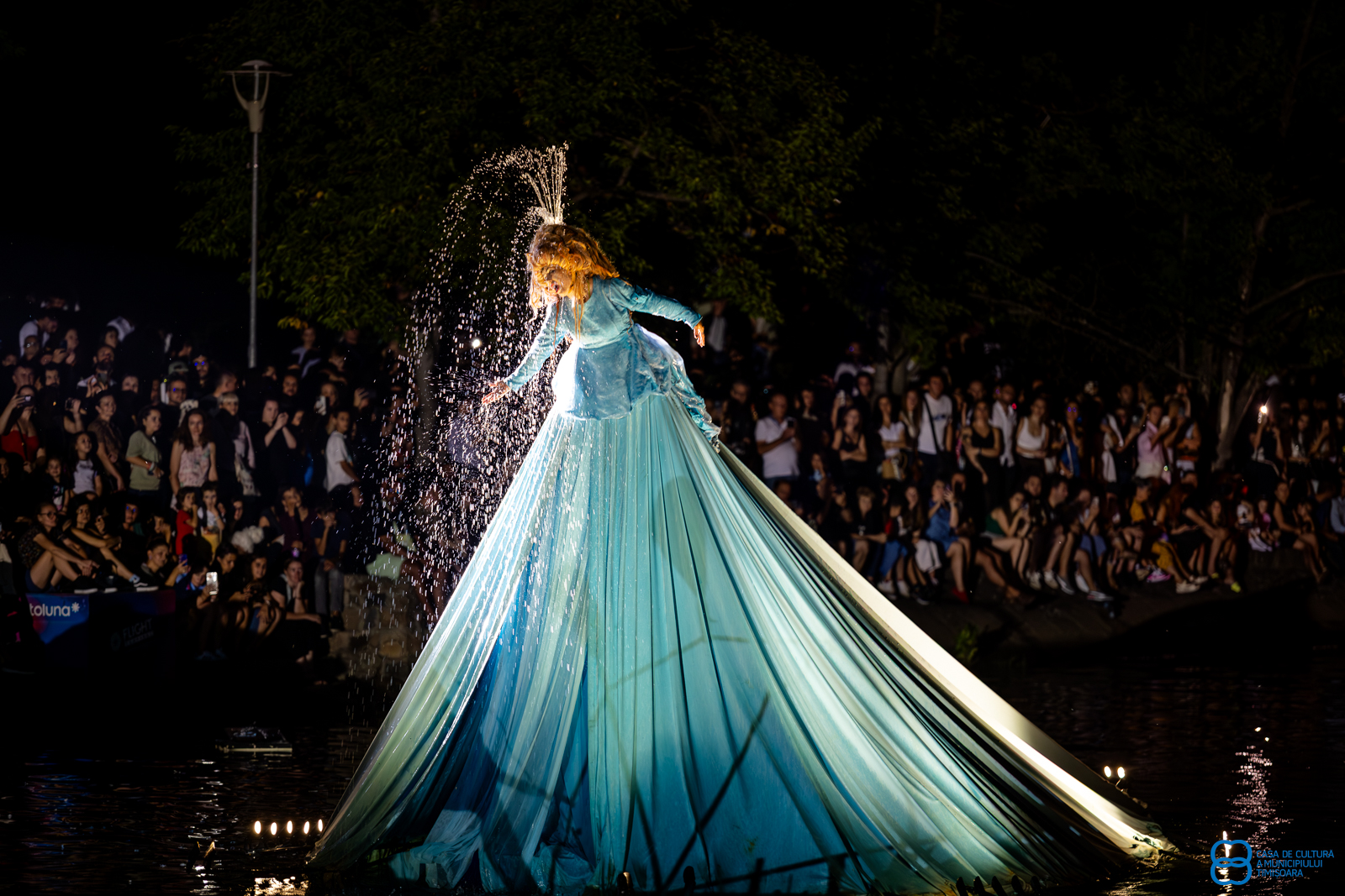 A glowing giant figure illuminates the lake, performing a water show.