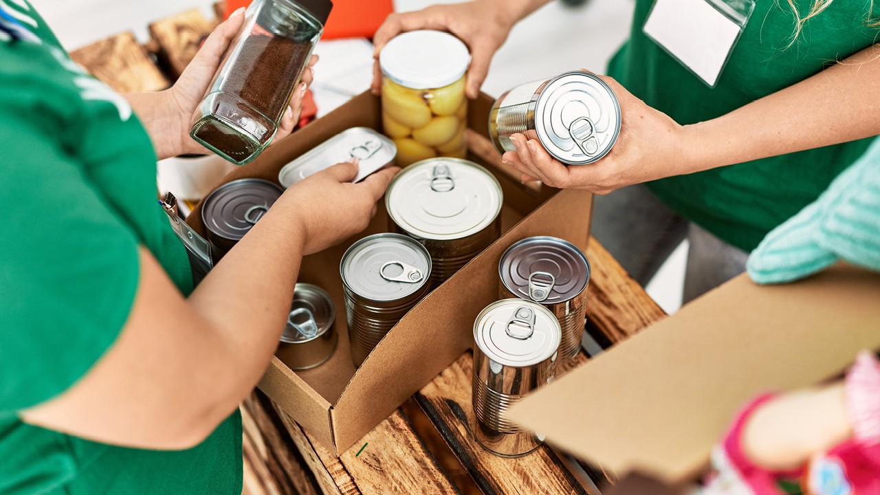 People packing a box of food donations