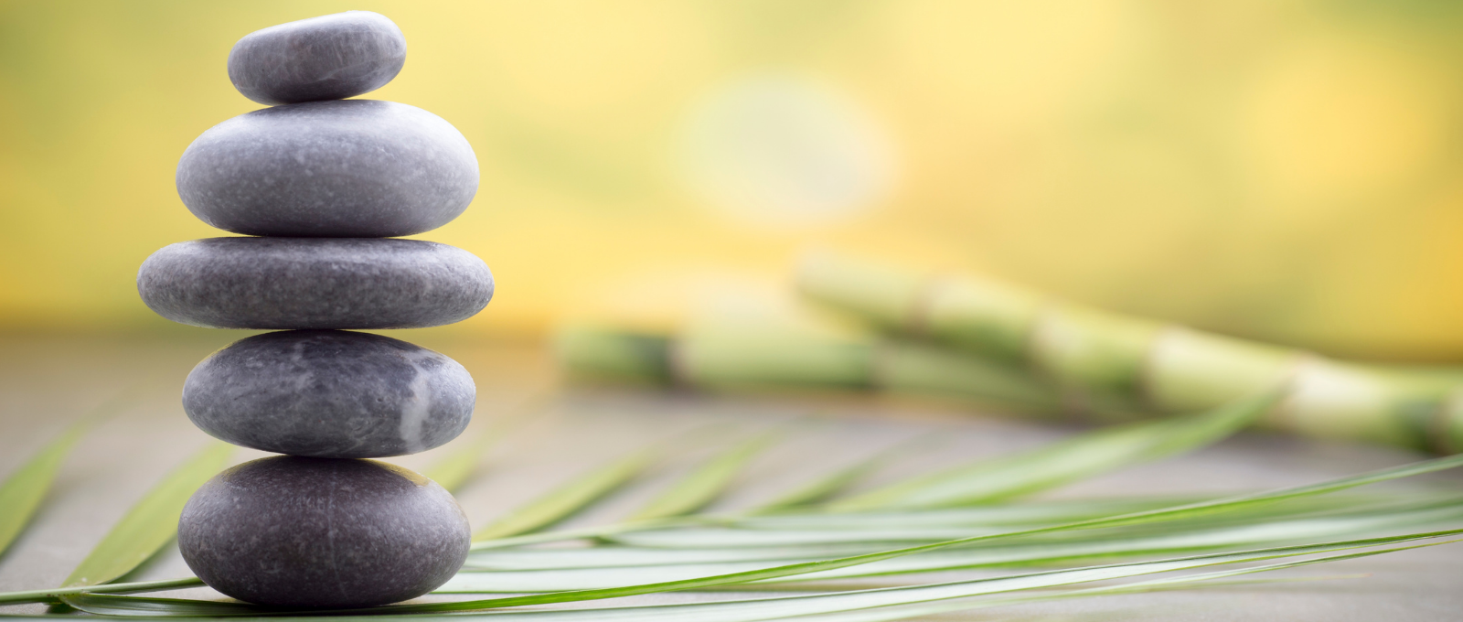 Three small rocks piled on top of each other in a calm setting