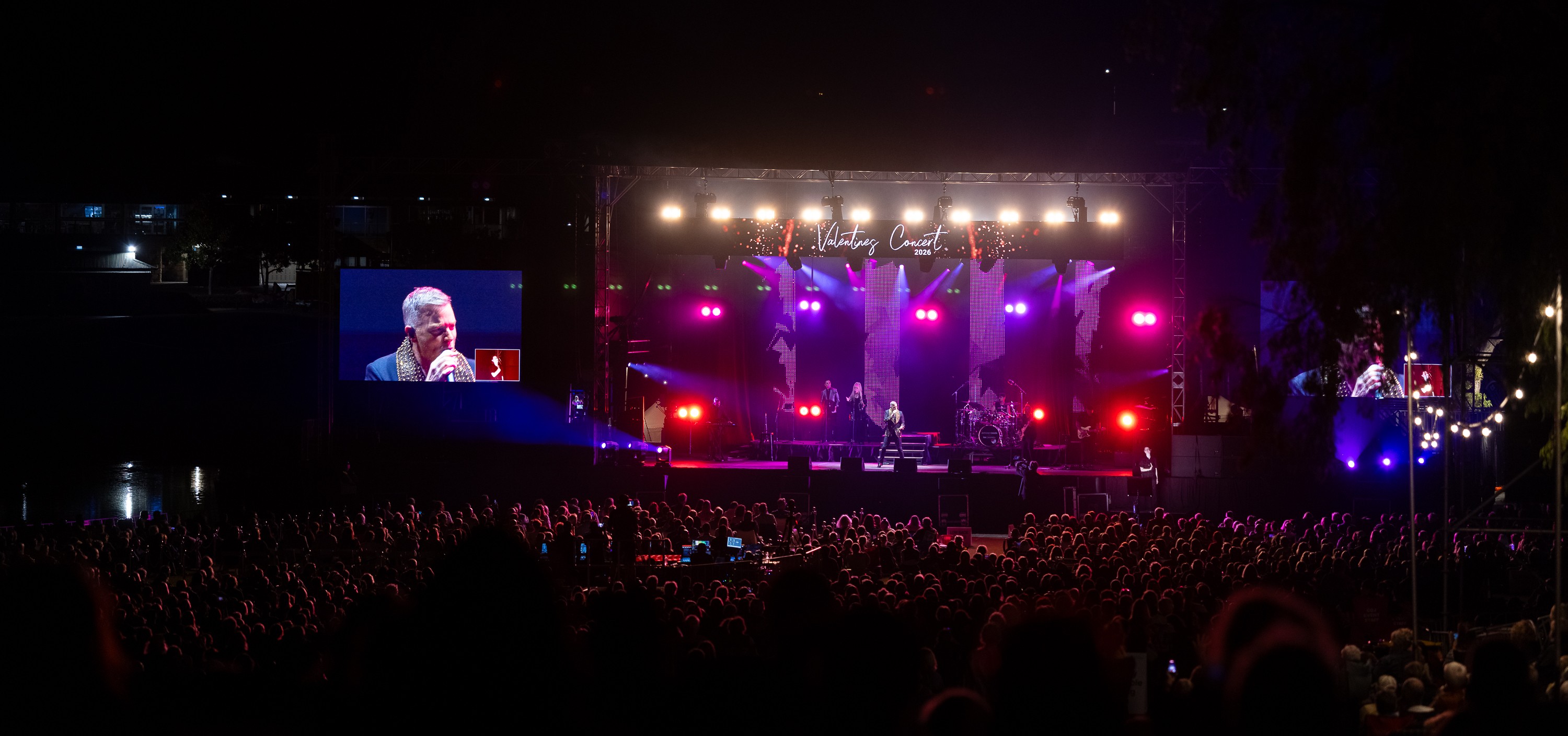 Crowds of people onlooking stage with pink strobe lights