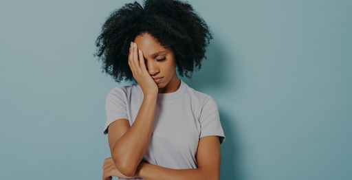 Lady with curly hair holding her head