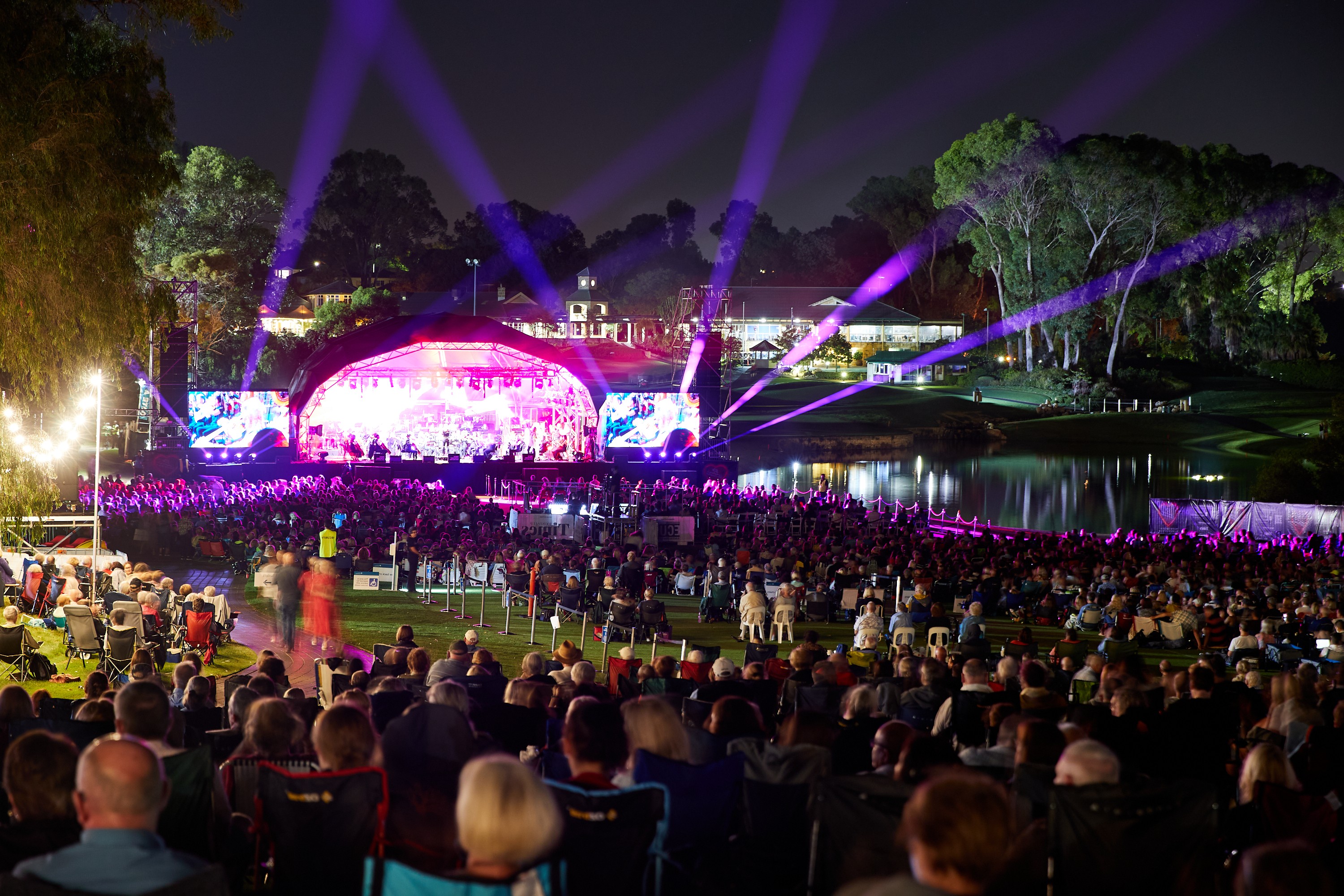 Crowds of people onlooking stage with pink strobe lights