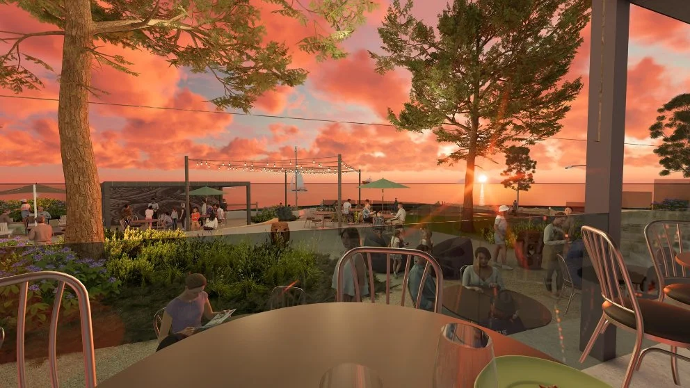 Sunset view from café terrace overlooking the ocean, with people dining, string lights and sailboats.