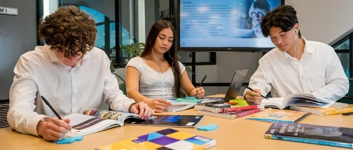 Three students studying in the library