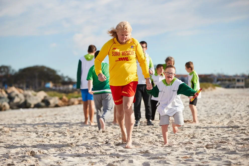 surf rescue lady running with child