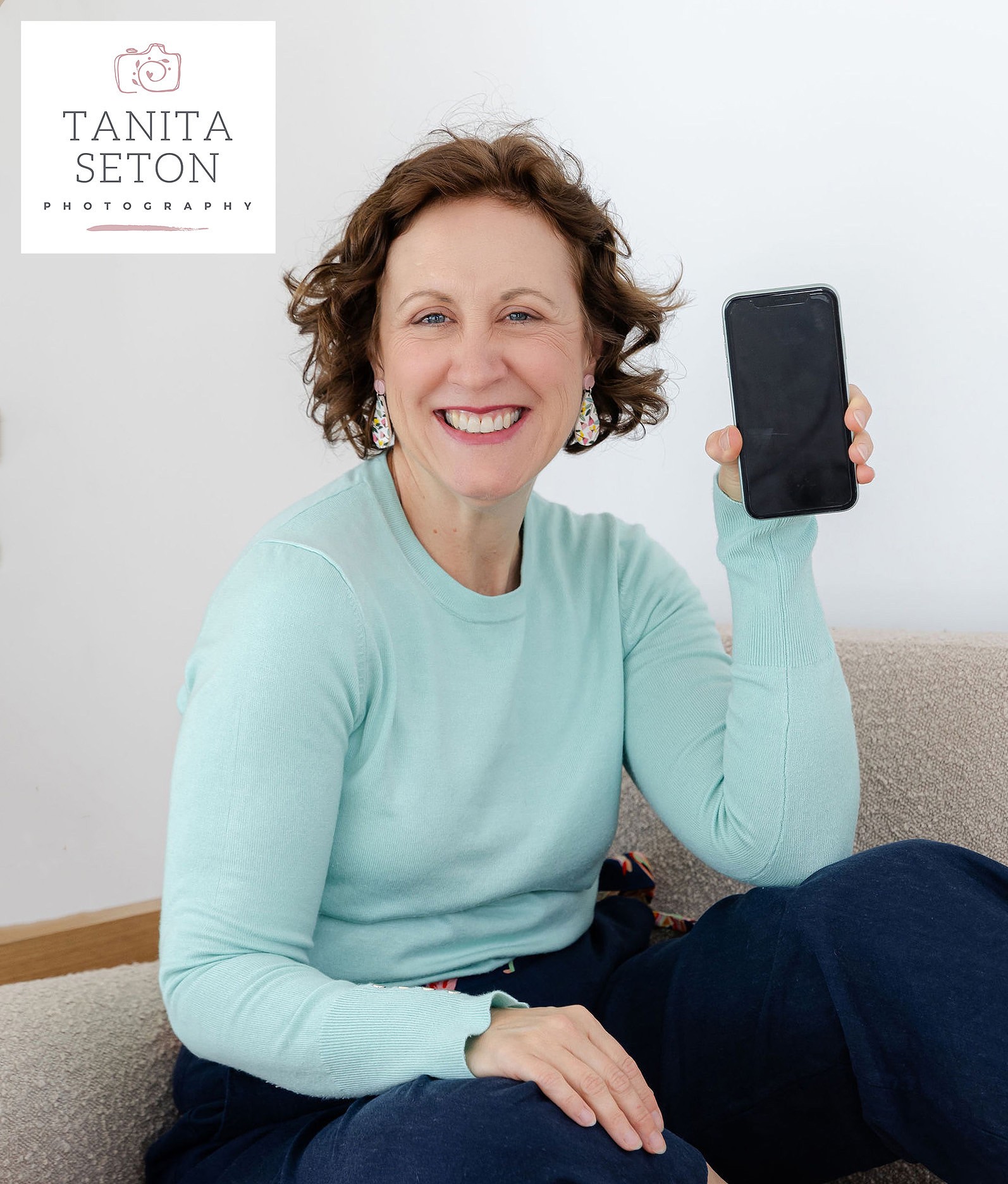 Lady in blue jumper holding a smartphone