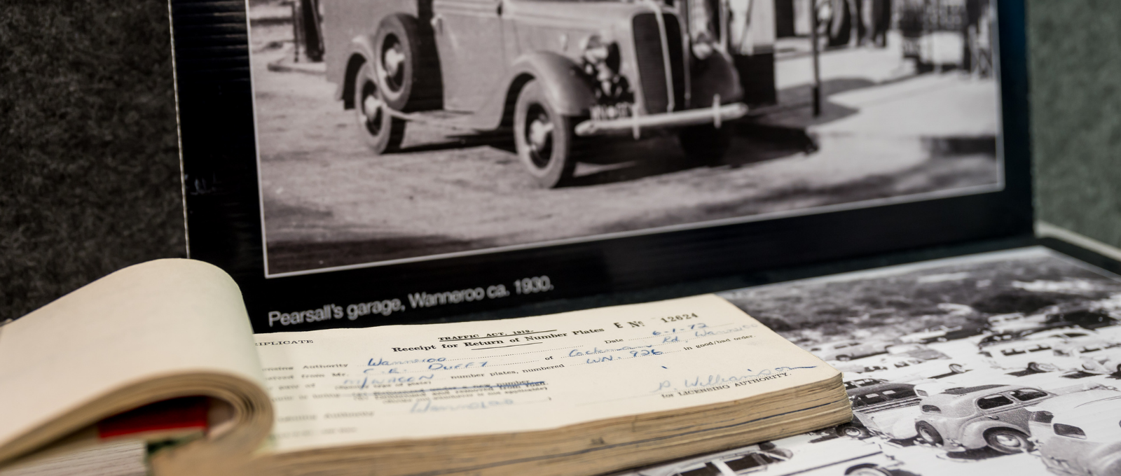 Black and white historical photo of a receipt book and a vintage car