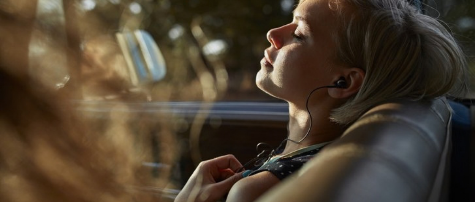 Person sitting calmly with headphones on practising stress management and wellbeing techniques.