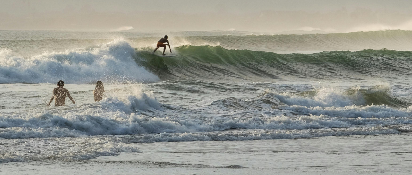 Three people surfing in the ocean