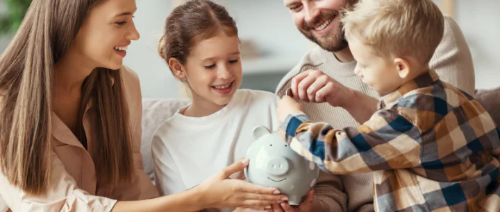 Family of four holding a piggy bank