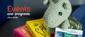 Crocheted dragon sitting on a pile of books holding a library card
