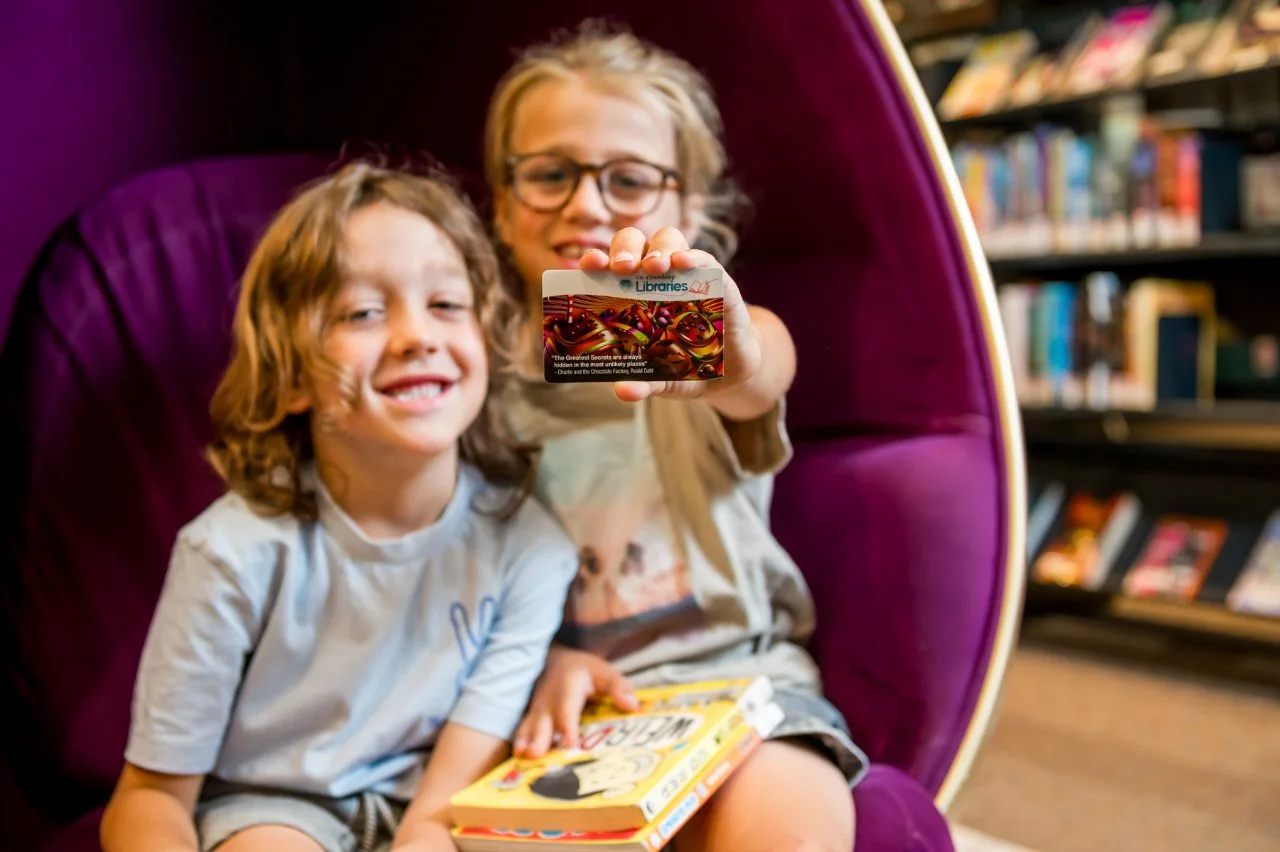 Two children sitting in purple egg chair