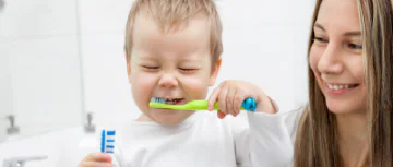 Mum with toddler brushing his teeth